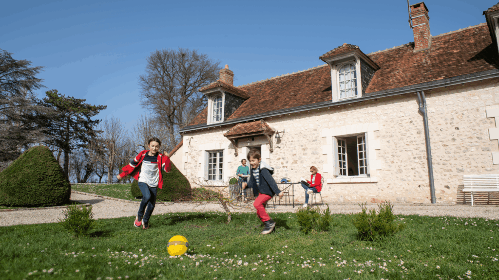 Les enfants profitent du grand jardin pour jouer au ballon