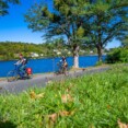 Balade en vélo au Lac d'Éguzon sous un ciel bleu, avec une vue panoramique sur l'eau et la nature environnante